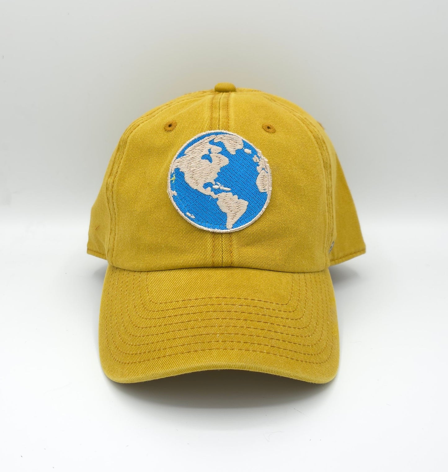 GORRA MOSTAZA CON PARCHE MAPA MUNDI